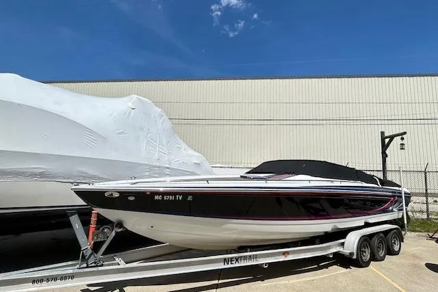 The Image of 2004 Formula 292 FASTech boat on trailer, black and white design, parked outdoors. - 1
