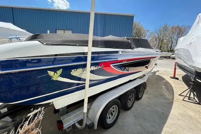 Slide: The Image of 2004 Formula 292 FASTech boat on a trailer, blue and white design, outdoor setting. - 6