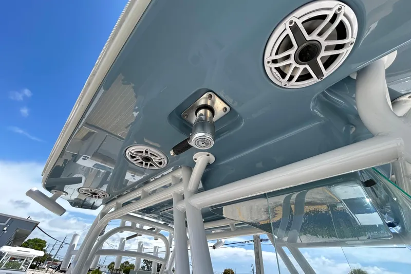 Slide: The Image of 2025 Cape Horn 34 XS boat roof with speakers and rod holders under clear blue sky. - 14