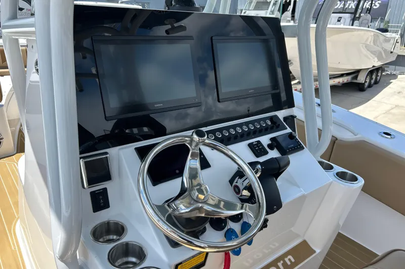 Slide: The Image of 2025 Cape Horn 34 XS boat dashboard with dual screens and steering wheel. - 5