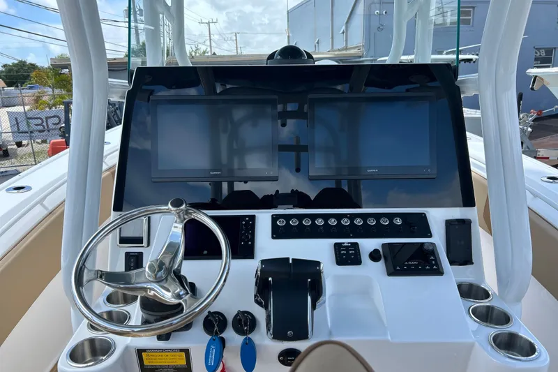 Slide: The Image of 2025 Cape Horn 34 XS boat dashboard with dual screens and steering wheel. - 6