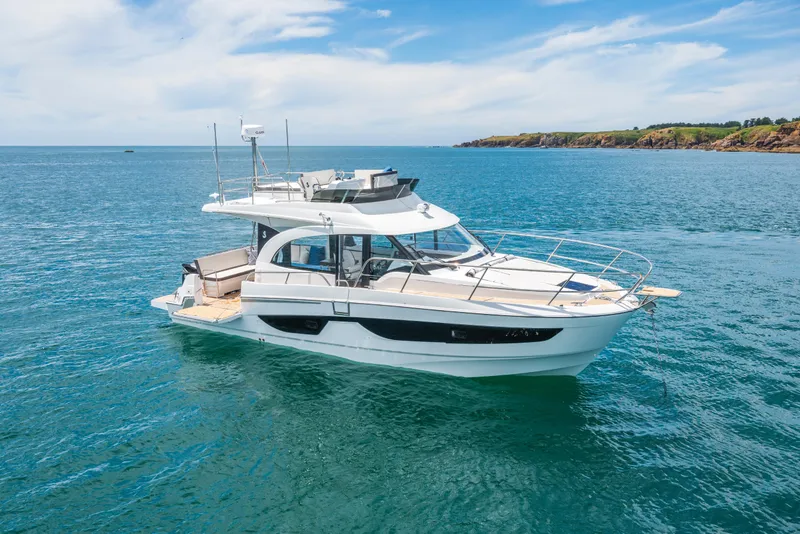 Slide: The Image of 2025 Beneteau Antares 11 Fly yacht on serene blue waters, coastal backdrop. - 11