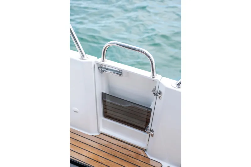 Slide: The Image of 2025 Beneteau Antares 11 Fly boat gate with teak deck and stainless steel railing. - 34
