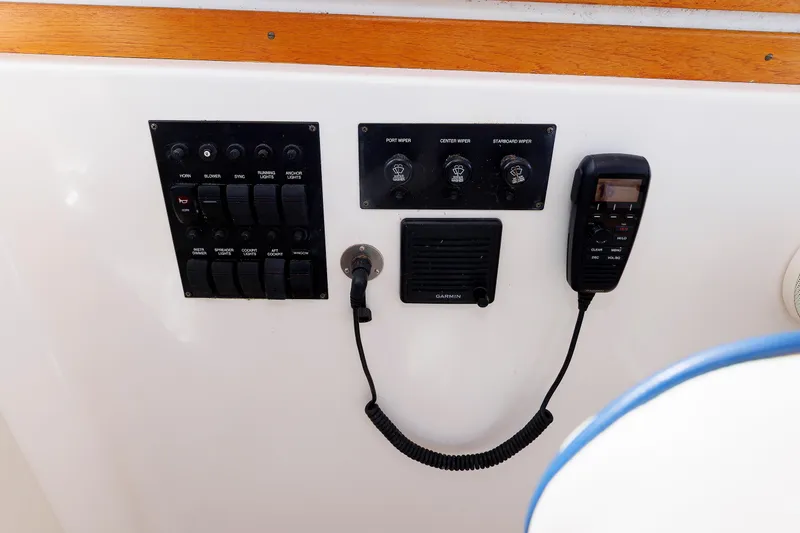 Slide: The Image of Control panel of a 2004 Sabre 42 Express boat with switches and communication device. - 14
