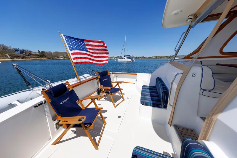 Slide: The Image of 2004 Sabre 42 Express yacht deck with chairs and American flag on a sunny day. - 22