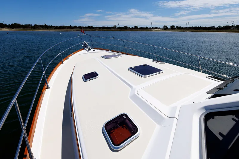 Slide: The Image of 2004 Sabre 42 Express yacht deck on calm water under clear sky. - 24
