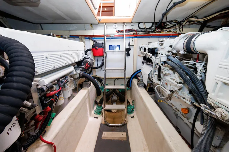 Slide: The Image of Engine room of a 2004 Sabre 42 Express yacht, featuring dual engines and ladder access. - 27