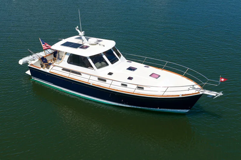 Slide: The Image of 2004 Sabre 42 Express yacht on calm water, featuring sleek design and American flag. - 3