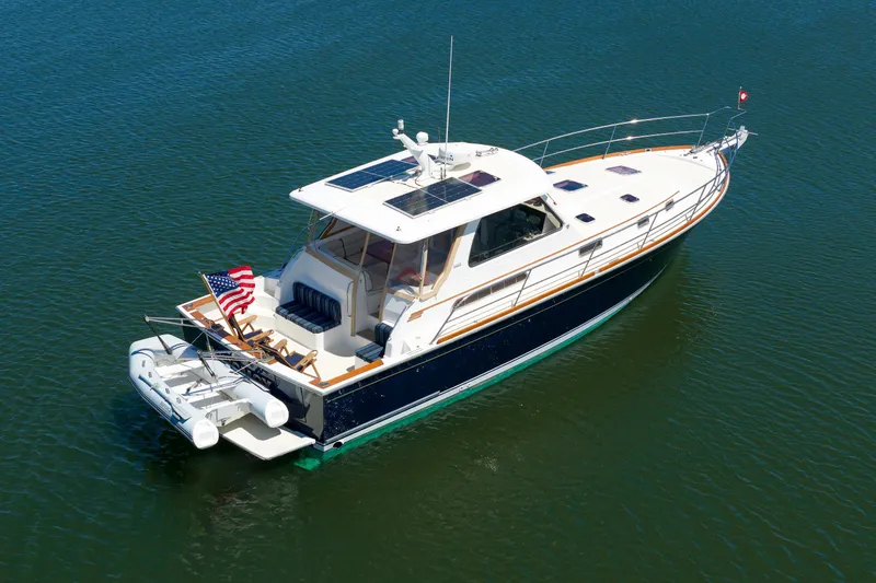 Slide: The Image of 2004 Sabre 42 Express yacht on calm water, featuring sleek design and American flag. - 4