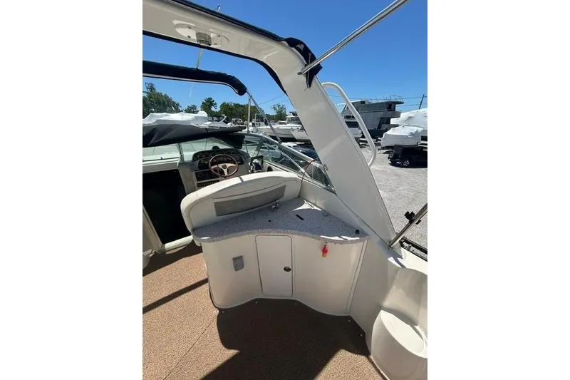 Slide: The Image of 2001 Rinker 310 Express Cruiser interior with helm and seating area under blue sky. - 10