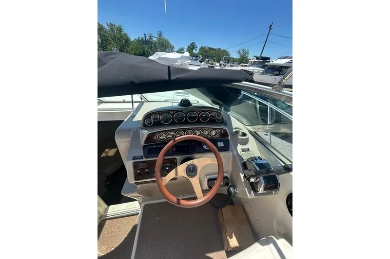 Slide: The Image of 2001 Rinker 310 Express Cruiser cockpit with steering wheel and instrument panel. - 14