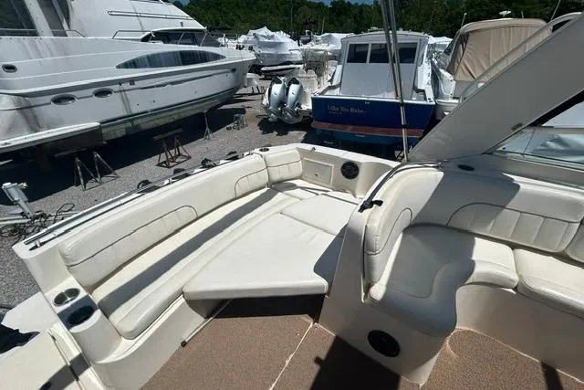 Slide: The Image of 2001 Rinker 310 Express Cruiser interior with white seating, docked among other boats. - 15