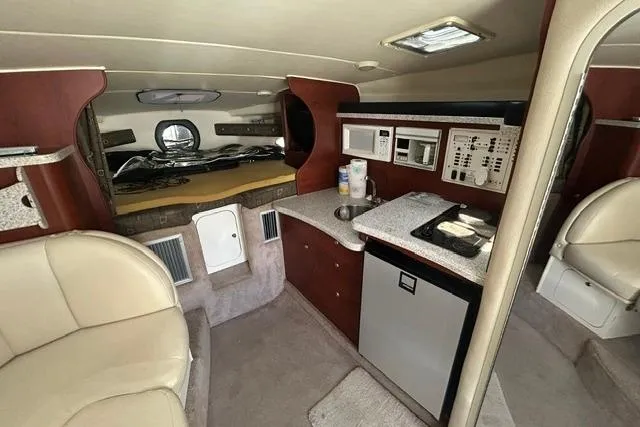 Slide: The Image of Interior of a 2001 Rinker 310 Express Cruiser with kitchenette and seating area. - 17