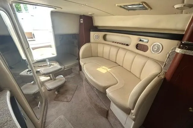 Slide: The Image of Interior of 2001 Rinker 310 Express Cruiser with beige seating and compact dining area. - 18