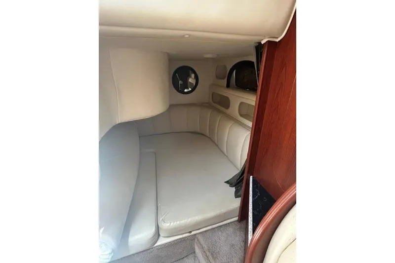 Slide: The Image of Interior cabin of 2001 Rinker 310 Express Cruiser with beige seating and wood accents. - 19