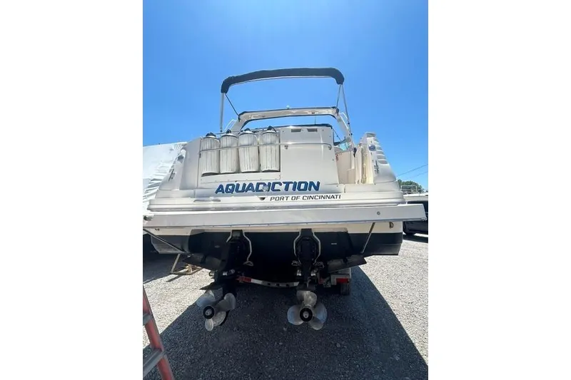 Slide: The Image of 2001 Rinker 310 Express Cruiser boat, rear view, docked under clear blue sky. - 4