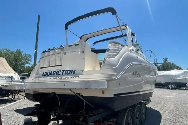 Slide: The Image of 2001 Rinker 310 Express Cruiser on trailer under clear blue sky. - 5