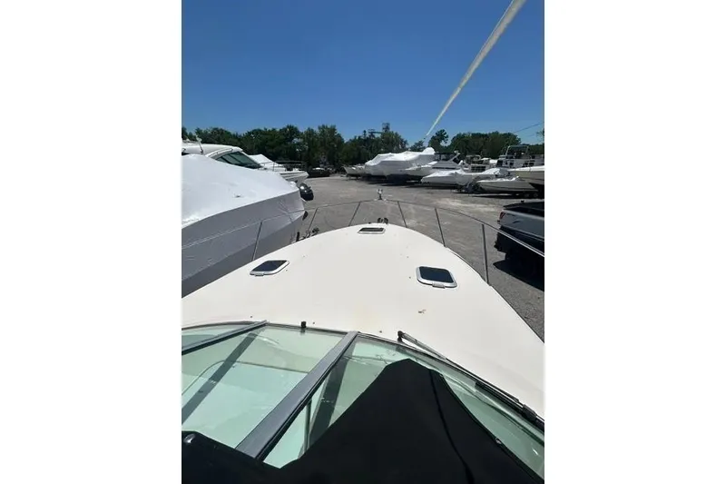 Slide: The Image of 2001 Rinker 310 Express Cruiser docked, surrounded by other boats under a clear blue sky. - 6