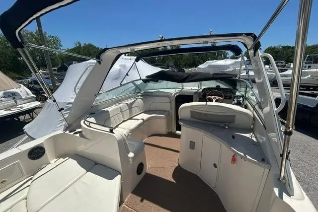 Slide: The Image of 2001 Rinker 310 Express Cruiser interior with seating and helm, under clear blue sky. - 7