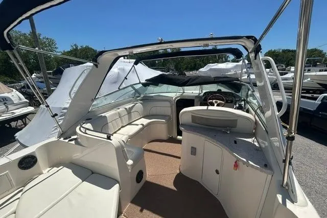 Slide: The Image of 2001 Rinker 310 Express Cruiser interior with seating and helm, under clear blue sky. - 8