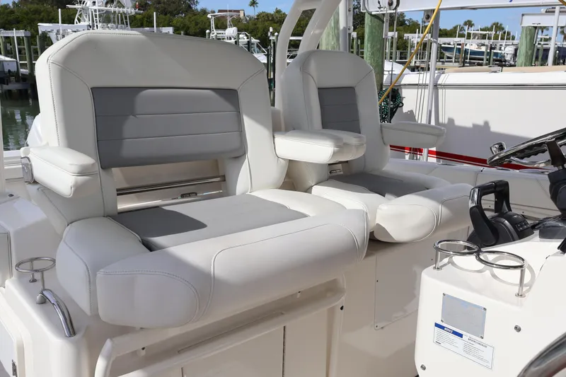 Slide: The Image of 2021 Pursuit S 328 Sport boat interior with dual white and gray captain seats. - 15