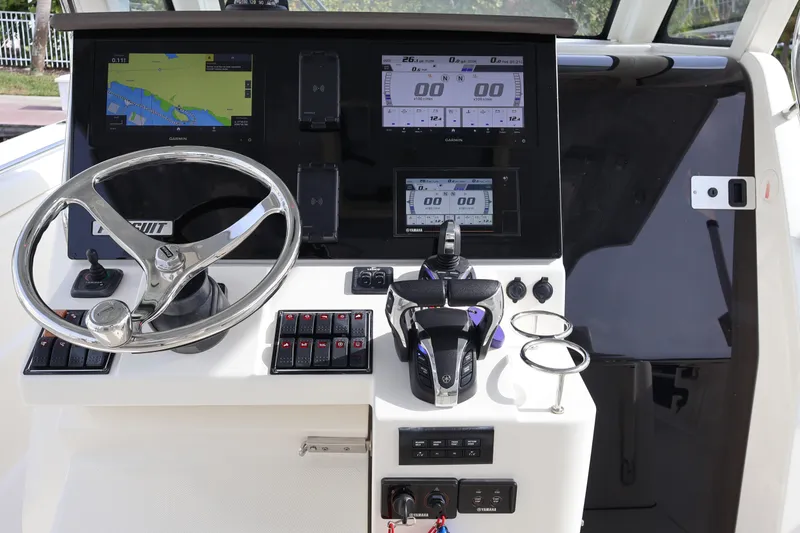 Slide: The Image of 2021 Pursuit S 328 Sport boat dashboard with steering wheel and navigation displays. - 19