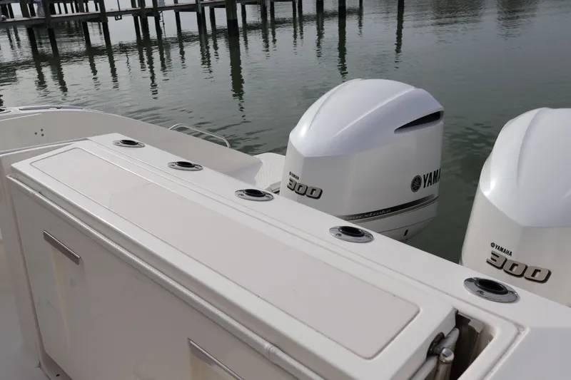 Slide: The Image of 2021 Pursuit S 328 Sport boat with twin Yamaha 300 engines docked by the water. - 30