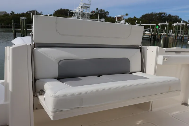 Slide: The Image of 2021 Pursuit S 328 Sport boat with comfortable seating, docked by the water. - 32