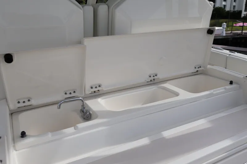 Slide: The Image of 2021 Pursuit S 328 Sport boat sink and storage compartments. - 40