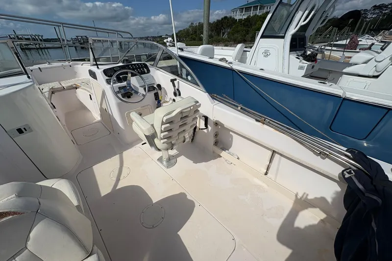 Slide: The Image of 2008 Grady-White Tournament 205 boat interior with steering wheel and seating, docked at marina. - 14