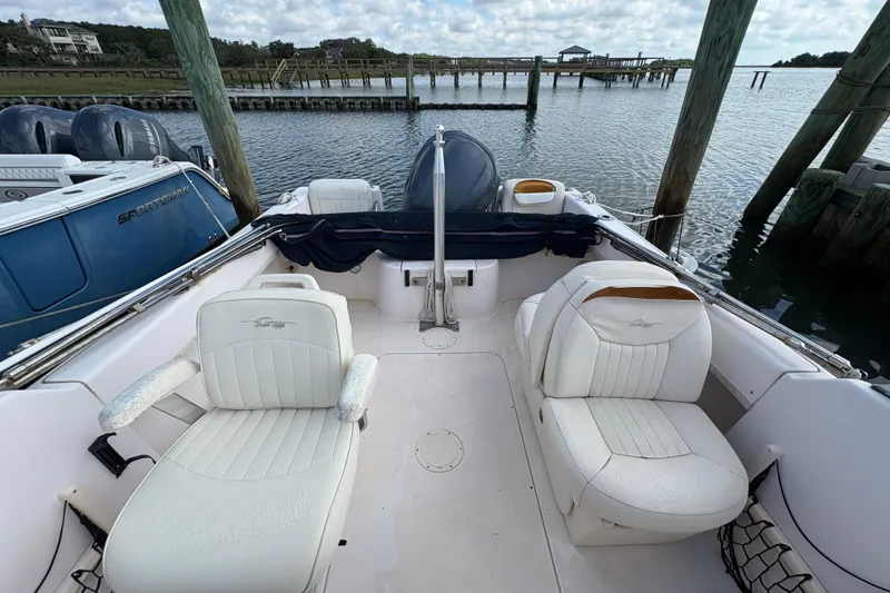 Slide: The Image of 2008 Grady-White Tournament 205 boat interior with white seating, docked by the water. - 16