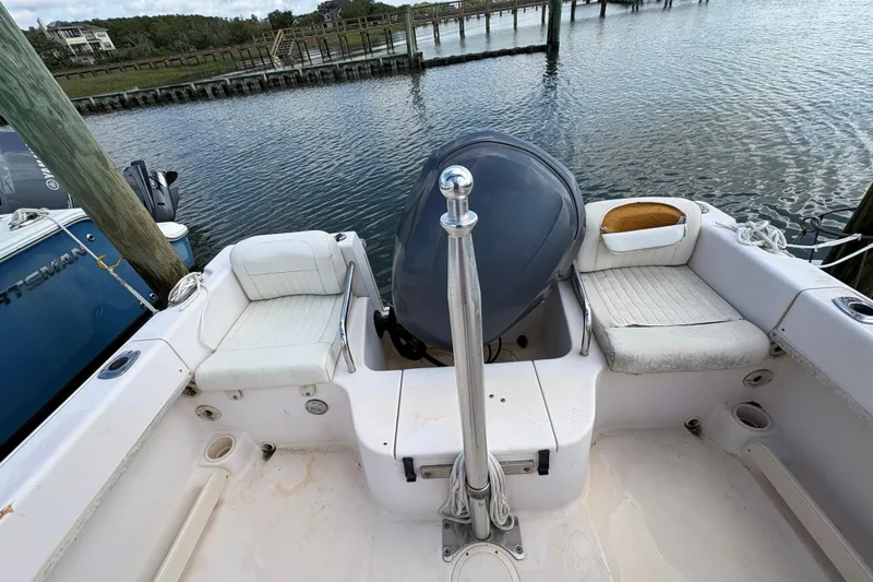 Slide: The Image of 2008 Grady-White Tournament 205 boat interior with seating and motor, docked by the water. - 17