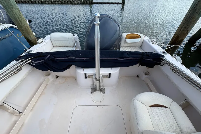 Slide: The Image of 2008 Grady-White Tournament 205 boat interior with seating and motor, docked by water. - 18