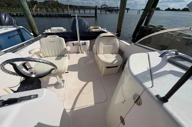 Slide: The Image of 2008 Grady-White Tournament 205 boat interior with seating and steering wheel, docked by the water. - 6