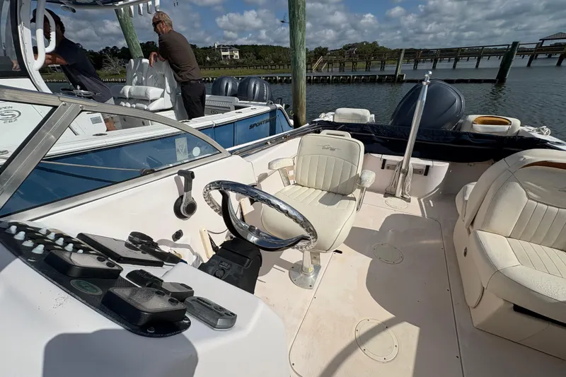 Slide: The Image of 2008 Grady-White Tournament 205 boat interior with steering wheel and seating, docked by the water. - 8
