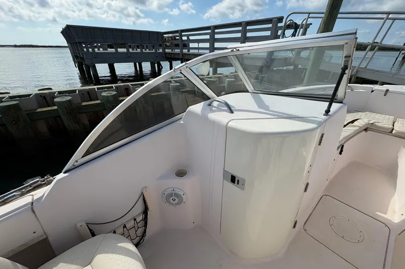 Slide: The Image of 2008 Grady-White Tournament 205 boat interior with seating and storage, docked by the water. - 9