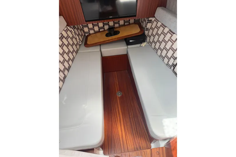 Slide: The Image of 2023 Pursuit S 428 Sport cabin interior with seating, table, and TV. - 10