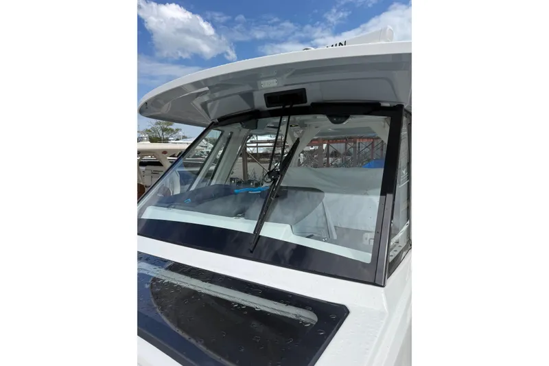 Slide: The Image of 2023 Pursuit S 428 Sport boat windshield under a clear blue sky. - 14