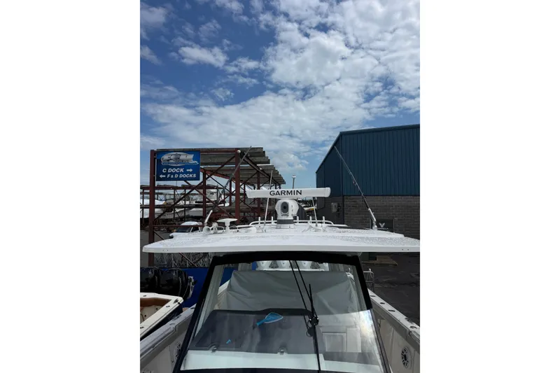 Slide: The Image of 2023 Pursuit S 428 Sport boat with Garmin radar, docked under a partly cloudy sky. - 15