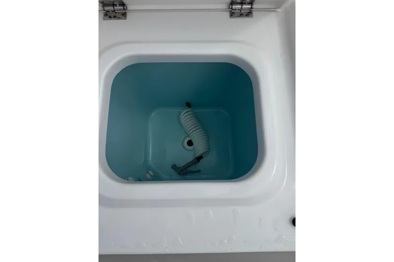 Slide: The Image of Storage compartment with coiled hose in 2023 Pursuit S 428 Sport boat. - 16