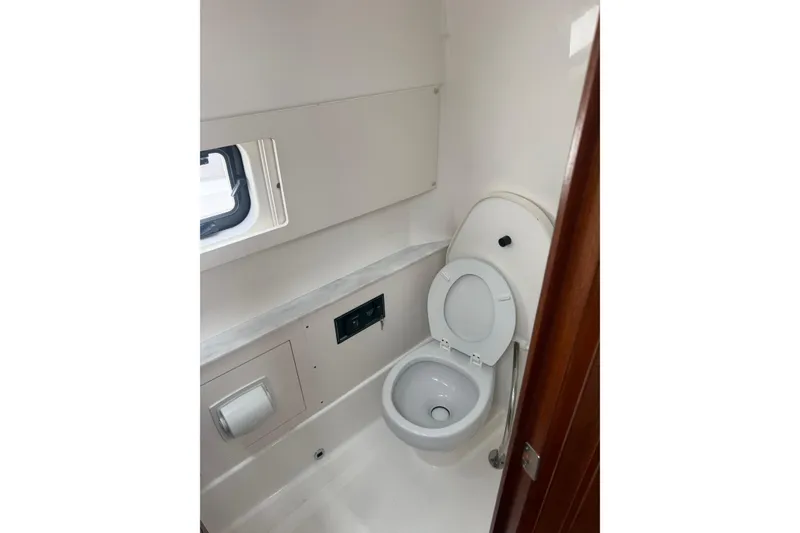 Slide: The Image of 2023 Pursuit S 428 Sport boat bathroom with toilet and window. - 9