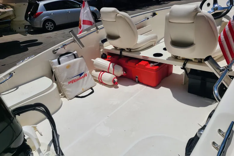 Slide: The Image of 2013 Boston Whaler 170 Super Sport interior with seats, storage, and safety equipment. - 14
