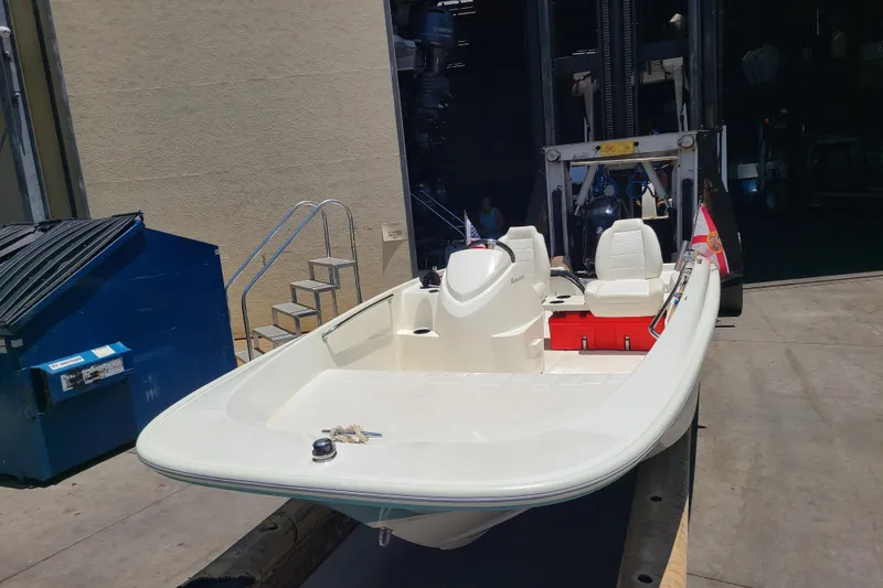 Slide: The Image of 2013 Boston Whaler 170 Super Sport boat in a dockyard setting. - 2