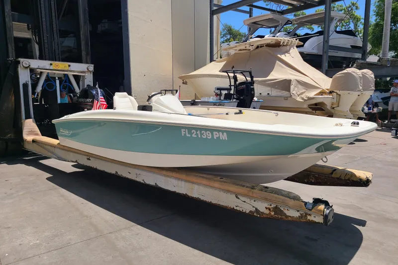 Slide: The Image of 2013 Boston Whaler 170 Super Sport boat on a lift, with visible registration number. - 3