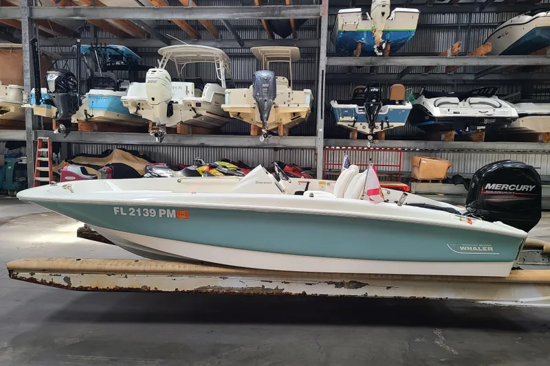 Slide: The Image of 2013 Boston Whaler 170 Super Sport boat in storage, featuring a Mercury engine. - 4