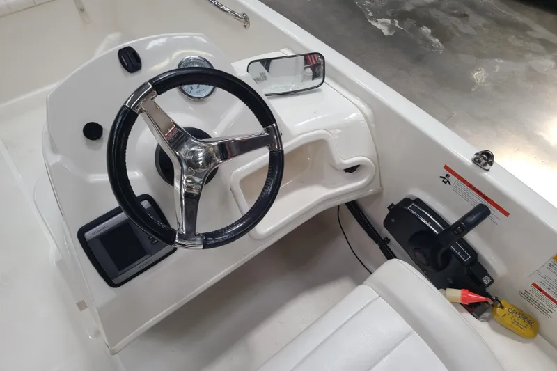 Slide: The Image of 2013 Boston Whaler 170 Super Sport boat steering console with controls and gauges. - 8