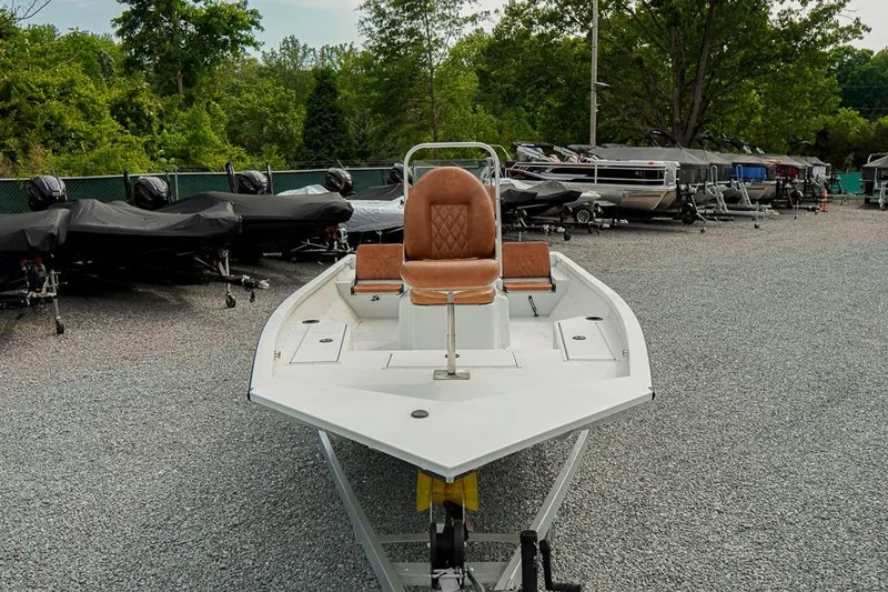 Slide: The Image of 2026 G3 Bay 21 GX Tunnel boat on gravel lot, surrounded by trees and other boats. - 5