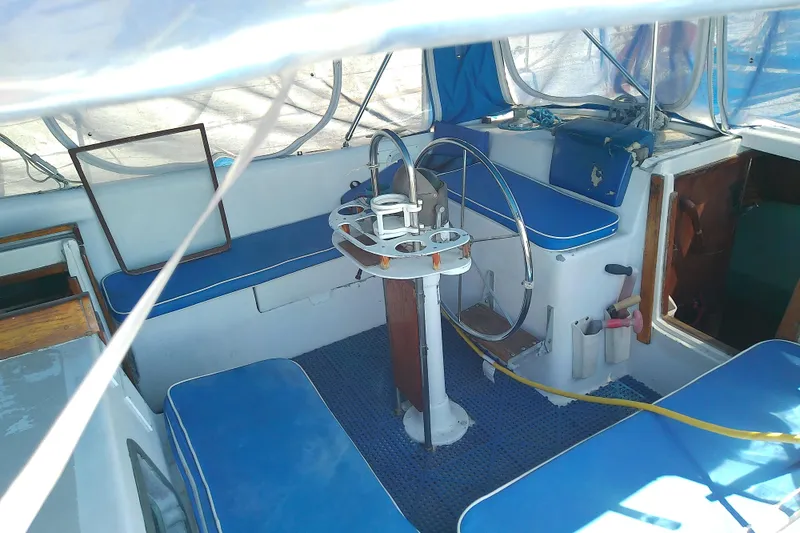 Slide: The Image of 1972 Morgan Out Island 41 sailboat cockpit with blue seating and steering wheel. - 20