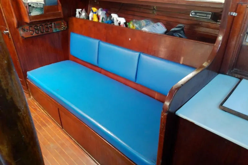 Slide: The Image of Interior of 1972 Morgan Out Island 41 sailboat with blue cushioned seating. - 23