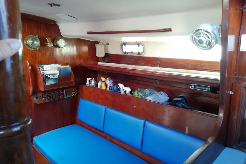 Slide: The Image of Interior of a 1972 Morgan Out Island 41 sailboat with blue seating and wooden accents. - 24